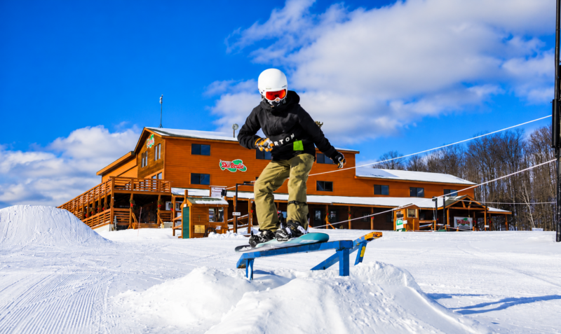 Snowboarder riding a terrain park rail at Ski Brule